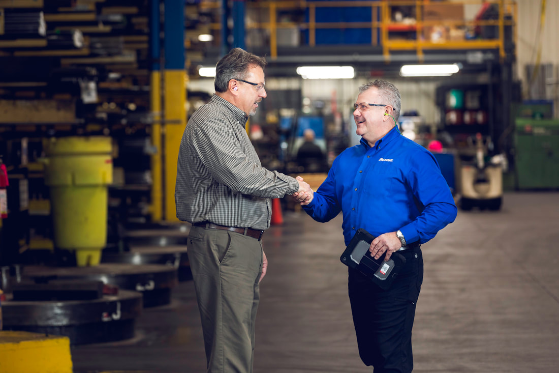 Two men shaking hands in warehouse