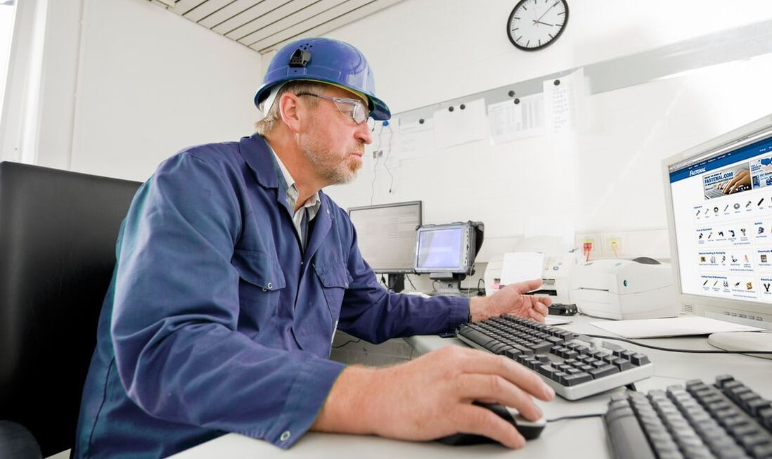 Employee in hard hat using computer