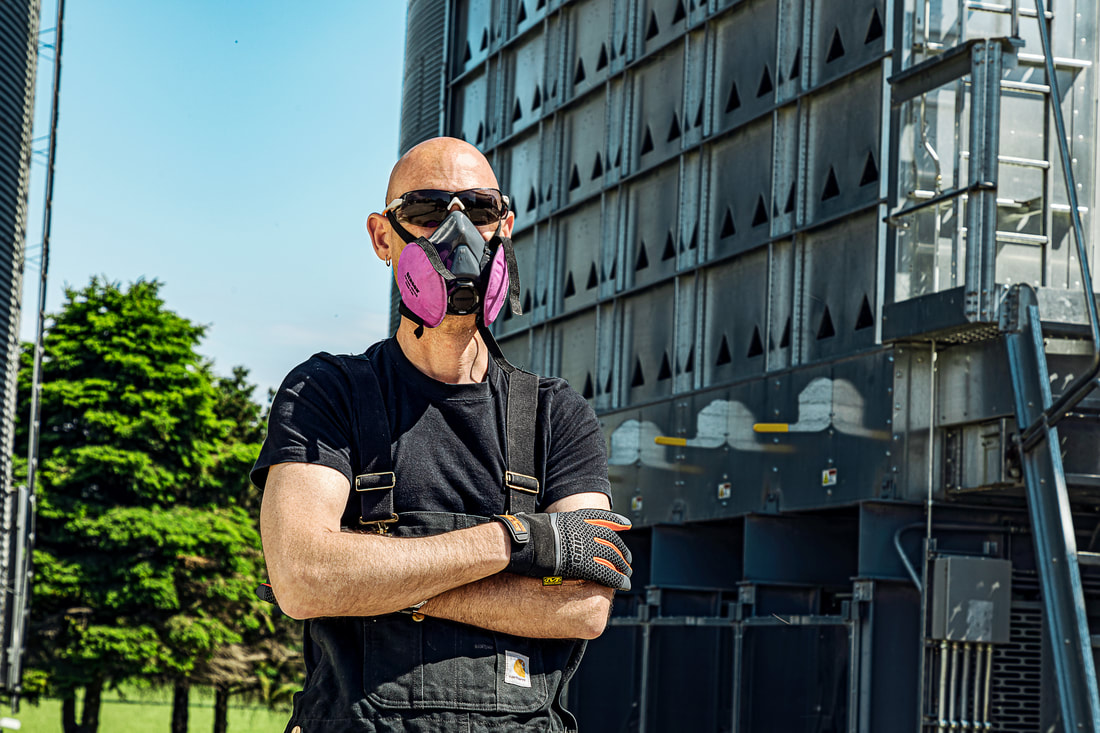 Man standing in front of building with respirator on